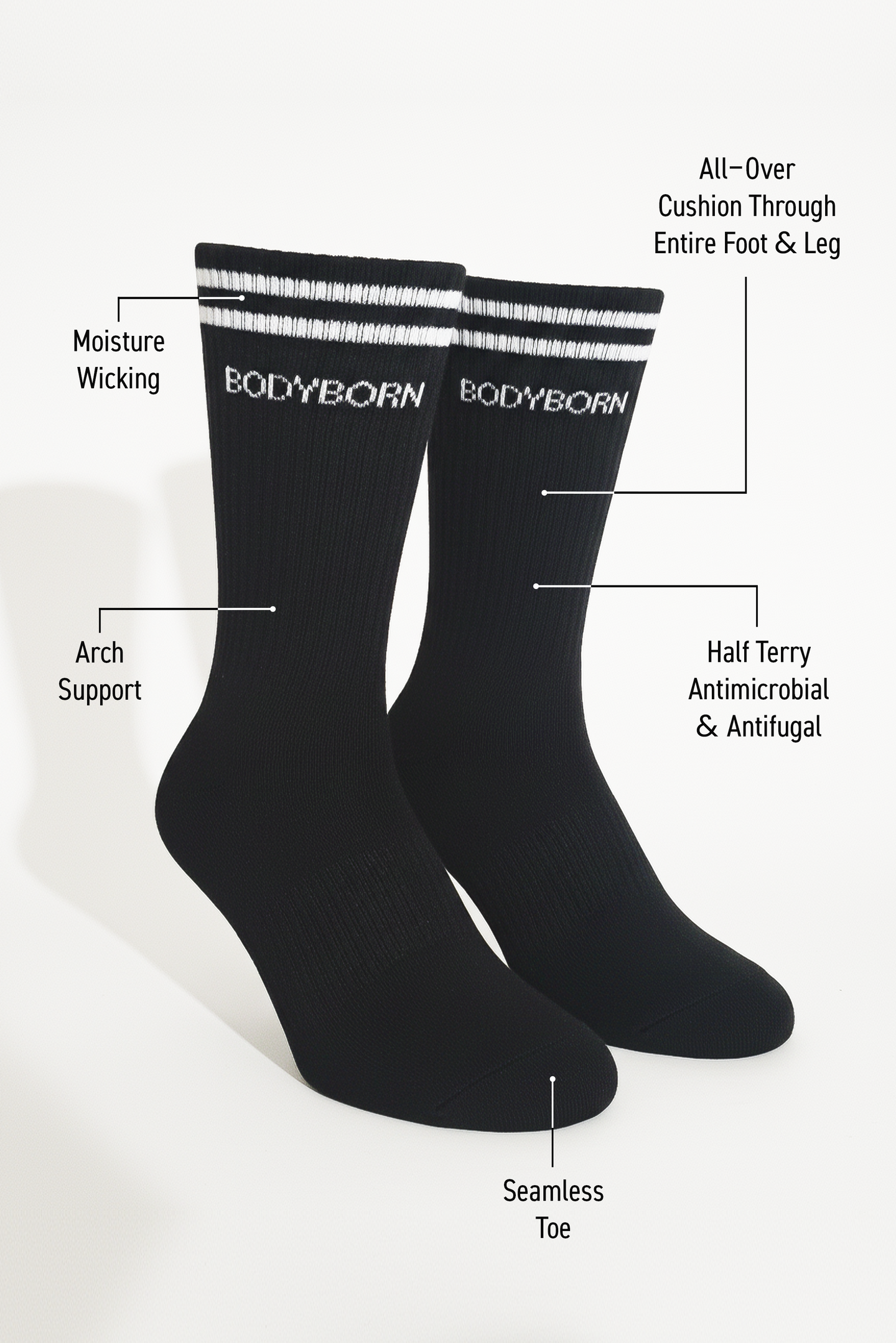 Two black BODYBORN crew-length socks with white stripe detailing, displayed upright and labeled with features including moisture-wicking fabric, arch support, all-over cushioning through the foot and leg, antimicrobial and antifungal half-terry construction and seamless toe