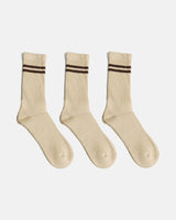 Three beige crew-length socks arranged in a row on a clean white background, each designed with ribbed texture and brown double-stripe detailing near the top