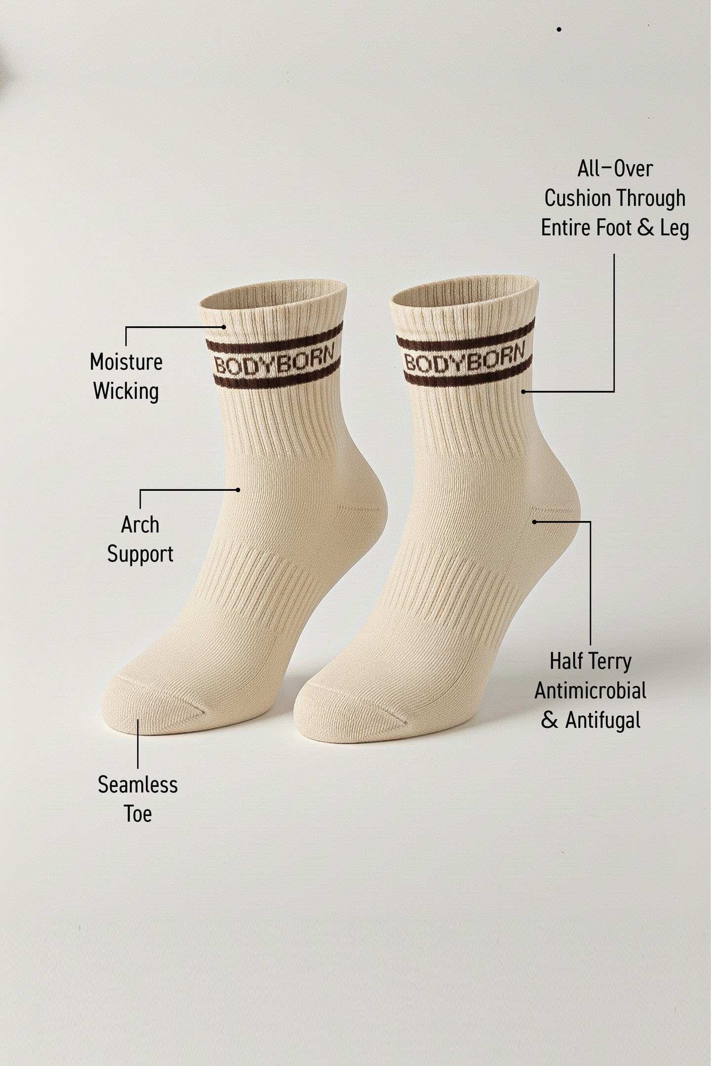 Two beige BODYBORN ankle-length socks with brown logo and stripe detail, displayed upright with labeled features including moisture-wicking material, arch support, antimicrobial and antifungal half-terry construction, all-over cushioning through the foot and leg, and seamless toe