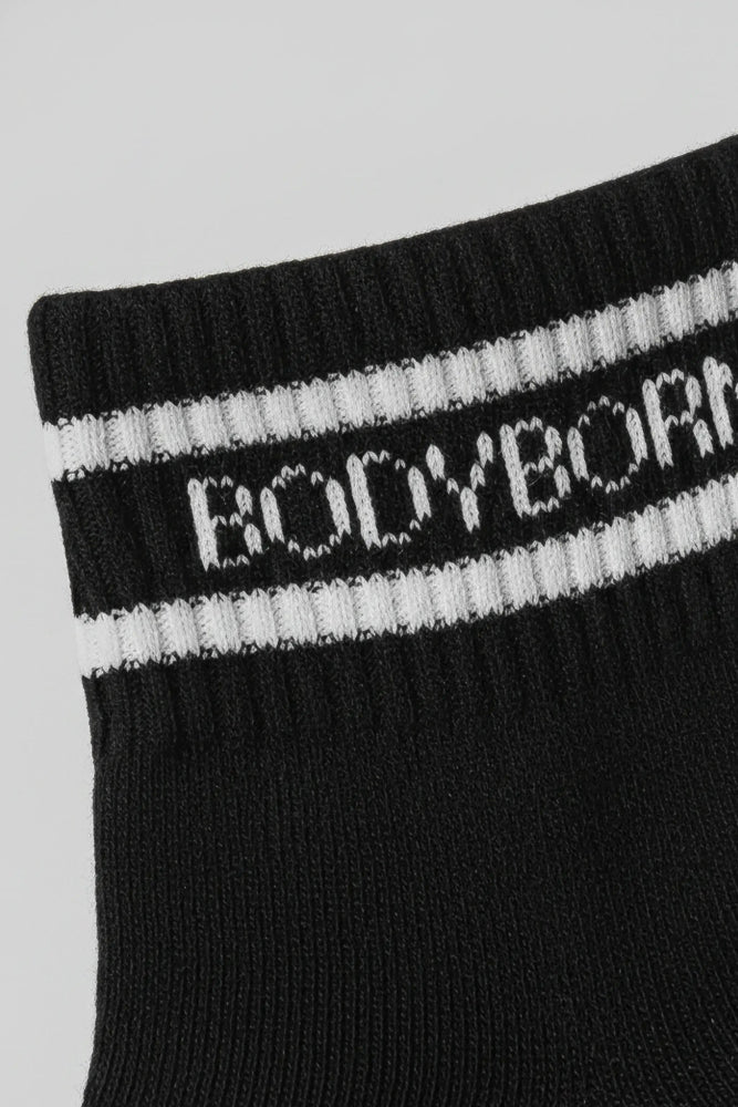 Black sock with white stripes and 'BODYBORN' branding on a light gray background with a premium feel, soft and comfortable