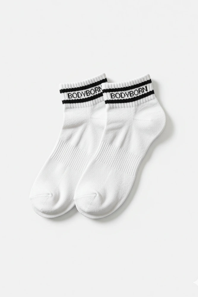 Bodyborn Glacier White socks with black bands worn by a person in ankle size