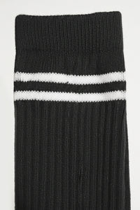 Black sock with two white stripes on a light gray background comfortable and soft