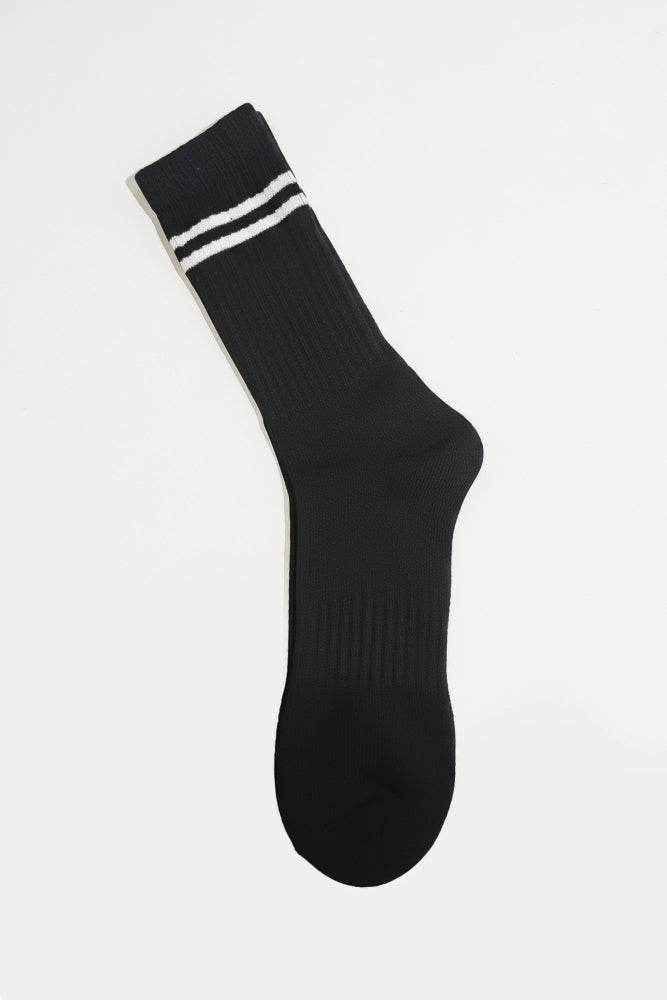 Black sock with white stripes on a light gray background in crew size soft and comfortable