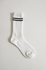 White sock with black stripes on a light gray background in crew size soft and comfortable
