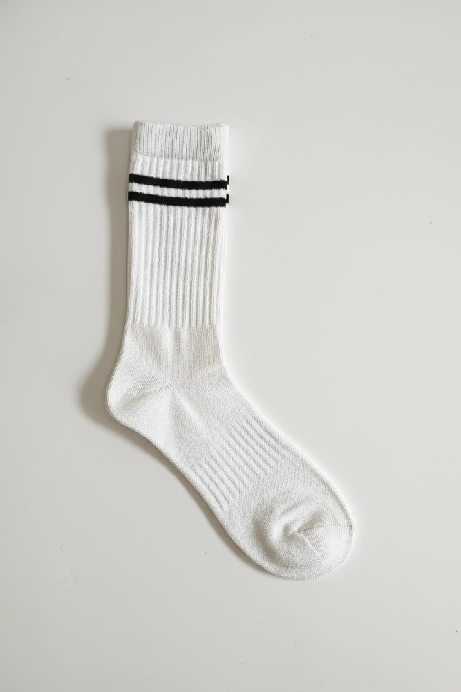 White sock with black stripes on a light gray background in crew size soft and comfortable