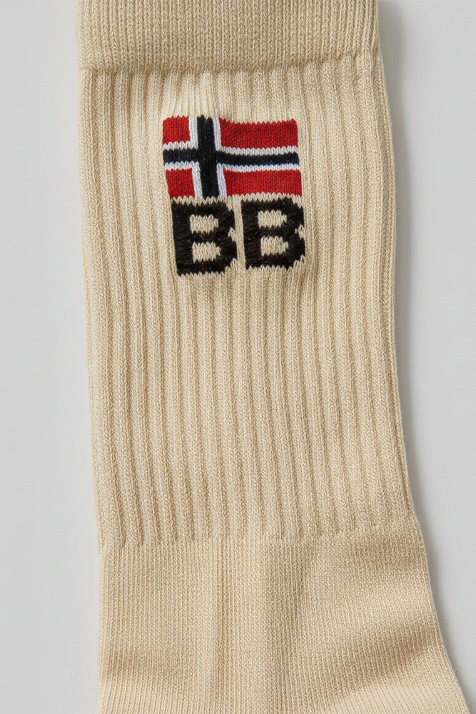 Beige sock with a knit bodyborn logo featuring a flag and text on a gray background in crew size premium soft and comfortable