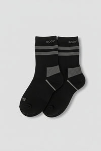 Pair of black socks with gray stripes on a light gray background  in crew size soft and comfortable