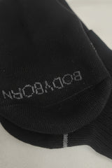 Black sock with 'Bodyborn' branding on a light gray background in crew size soft and comfortable