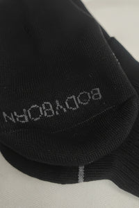 Black sock with 'Bodyborn' branding on a light gray background in crew size soft and comfortable