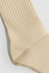 Beige sock on a light gray background with a premium feel, soft and comfortable
