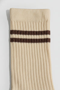 Beige sock with two brown stripes on a light gray background with a premium feel, soft and comfortable