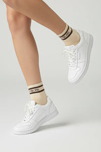 White sneakers and bodyborn beige socks with brown stripes on a light gray background premium feel, soft and comfortable