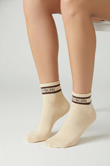 Beige socks with a bodyborn logo on a light gray background with premium feel, soft and comfortable