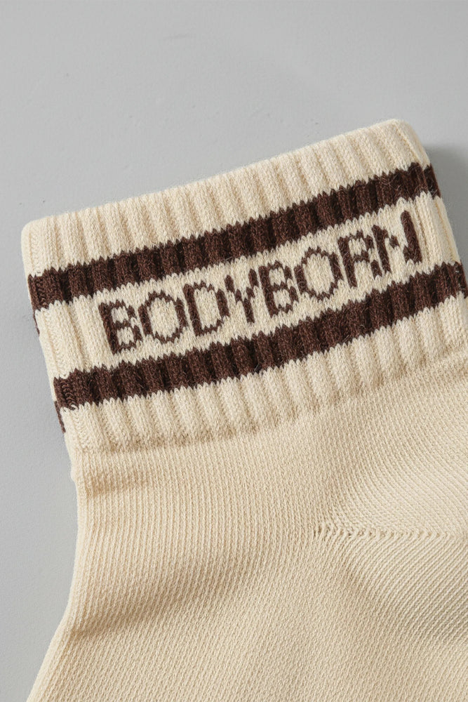 Beige sock with brown stripes and 'BODYBORN' branding on a gray background with premium feel, soft and comfortable
