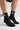 Black socks with a bodyborn logo worn by a person on a light gray background in ankle size soft and comfortable