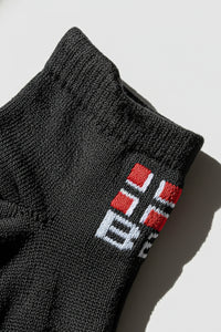Black sock with a bodyborn logo on a light gray background in low cut size soft and comfortable