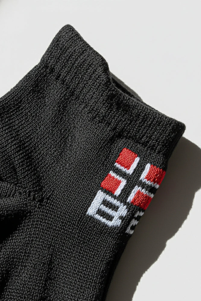 Black sock with a bodyborn logo on a light gray background in low cut size soft and comfortable