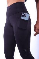  Black gym leggings with secure side pocket holding a phone.​

