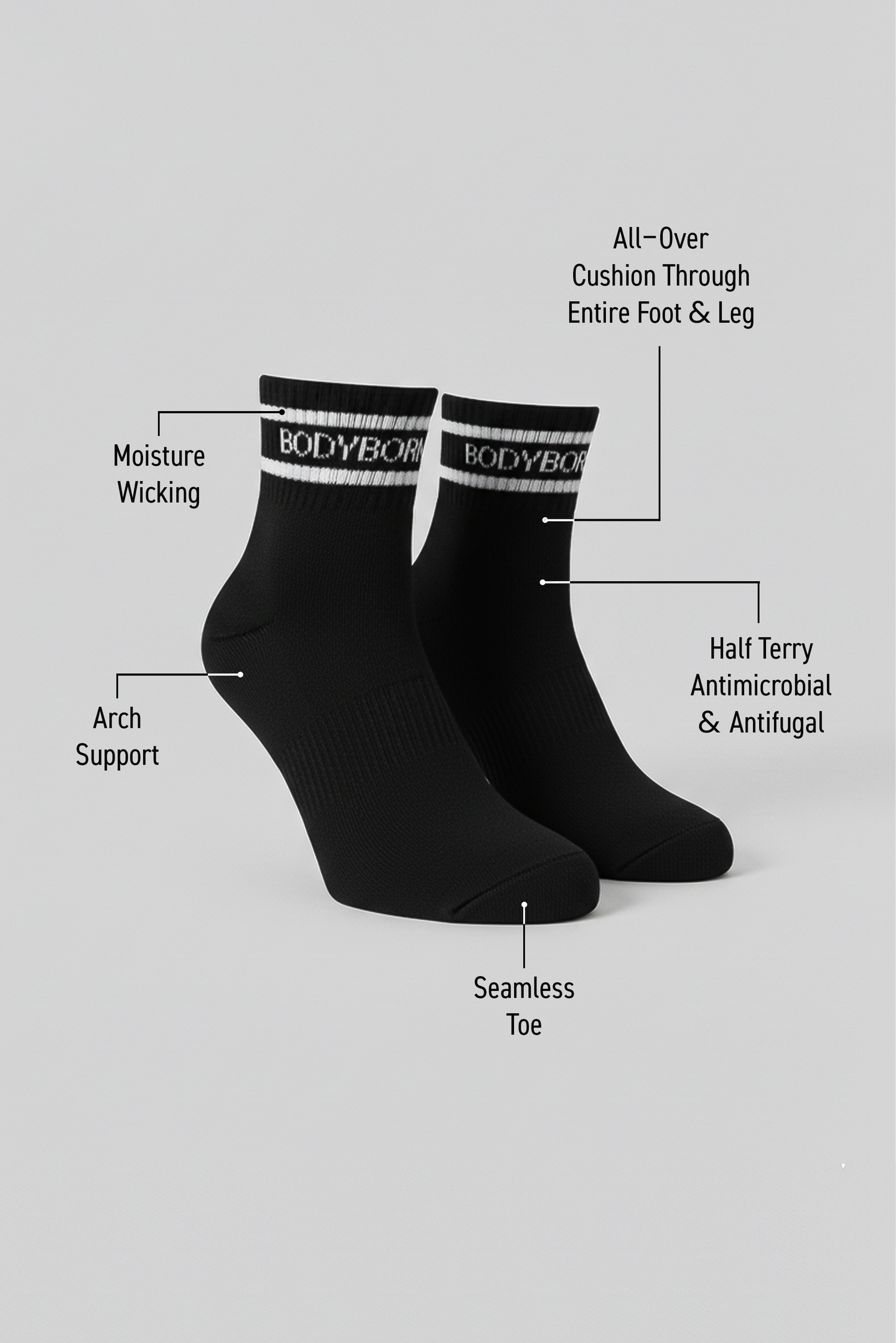 Two black BODYBORN ankle-length socks displayed upright with white logo stripe, labeled with moisture-wicking material, arch support, antimicrobial and antifungal half-terry construction, all-over cushioning through the foot and leg, and seamless toe