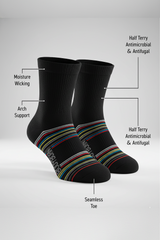 Two black BODYBORN crew-length socks displayed upright with colorful horizontal stripes, featuring labelled benefits including moisture-wicking material, arch support, antimicrobial and antifungal half-terry construction, all-over cushioning and seamless toe