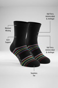 Two black BODYBORN crew-length socks displayed upright with colorful horizontal stripes, featuring labelled benefits including moisture-wicking material, arch support, antimicrobial and antifungal half-terry construction, all-over cushioning and seamless toe
