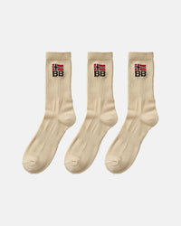Three beige crew-length socks arranged in a row on a white background, each showing ribbed fabric and an embroidered BB logo beneath a red and white flag symbol