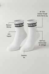 Two white BODYBORN crew-length socks displayed upright with black striping, featuring labelled benefits such as moisture-wicking material, arch support, all-over cushioning through the foot and leg, antimicrobial and antifungal half-terry construction, and a seamless toe