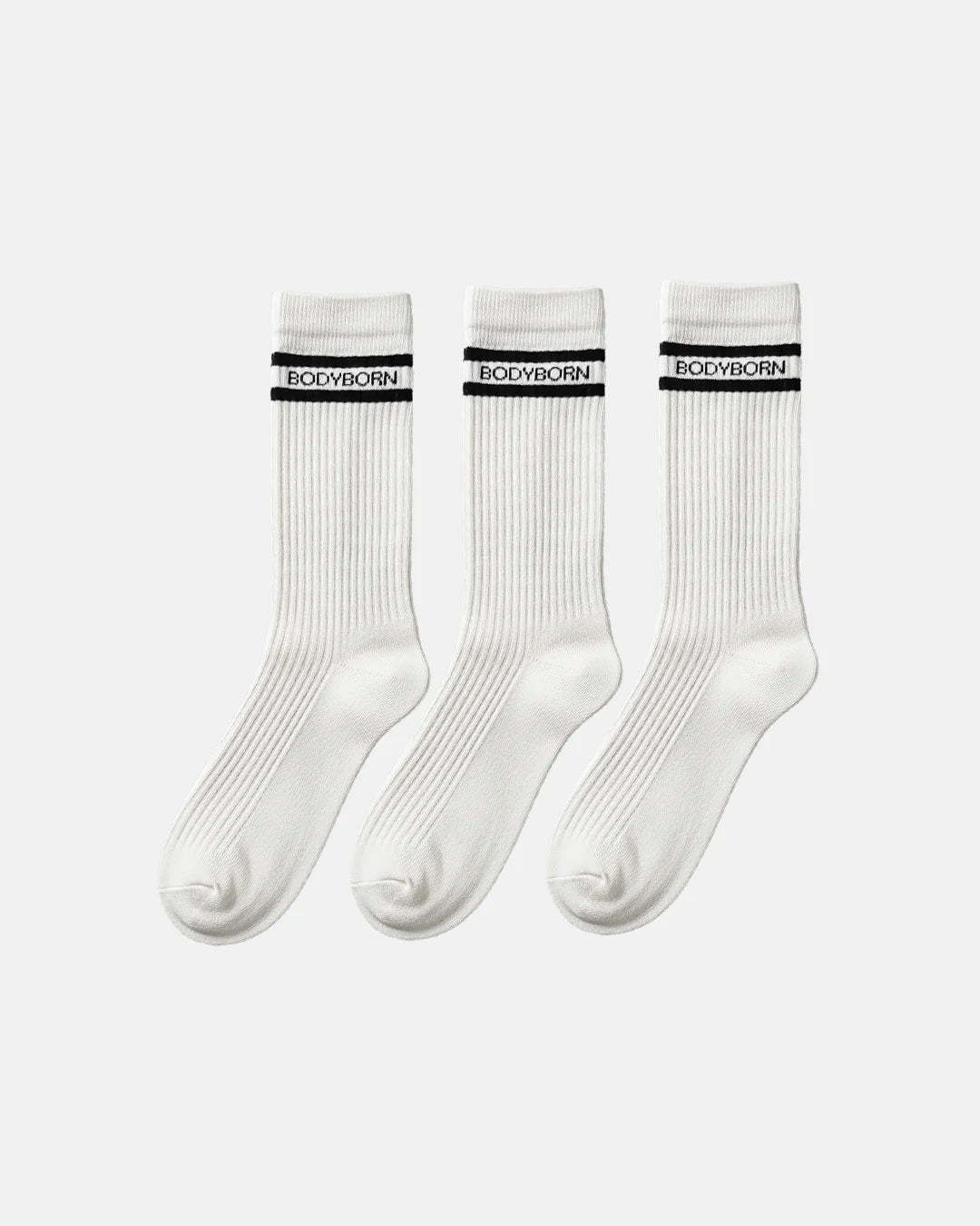 Three identical white crew socks arranged in a row, each designed with ribbed texture and a black double stripe featuring BODYBORN branding across the cuff